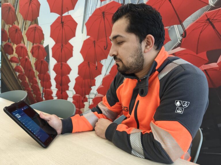 Électricien regarde sa planification sur sa tablette.